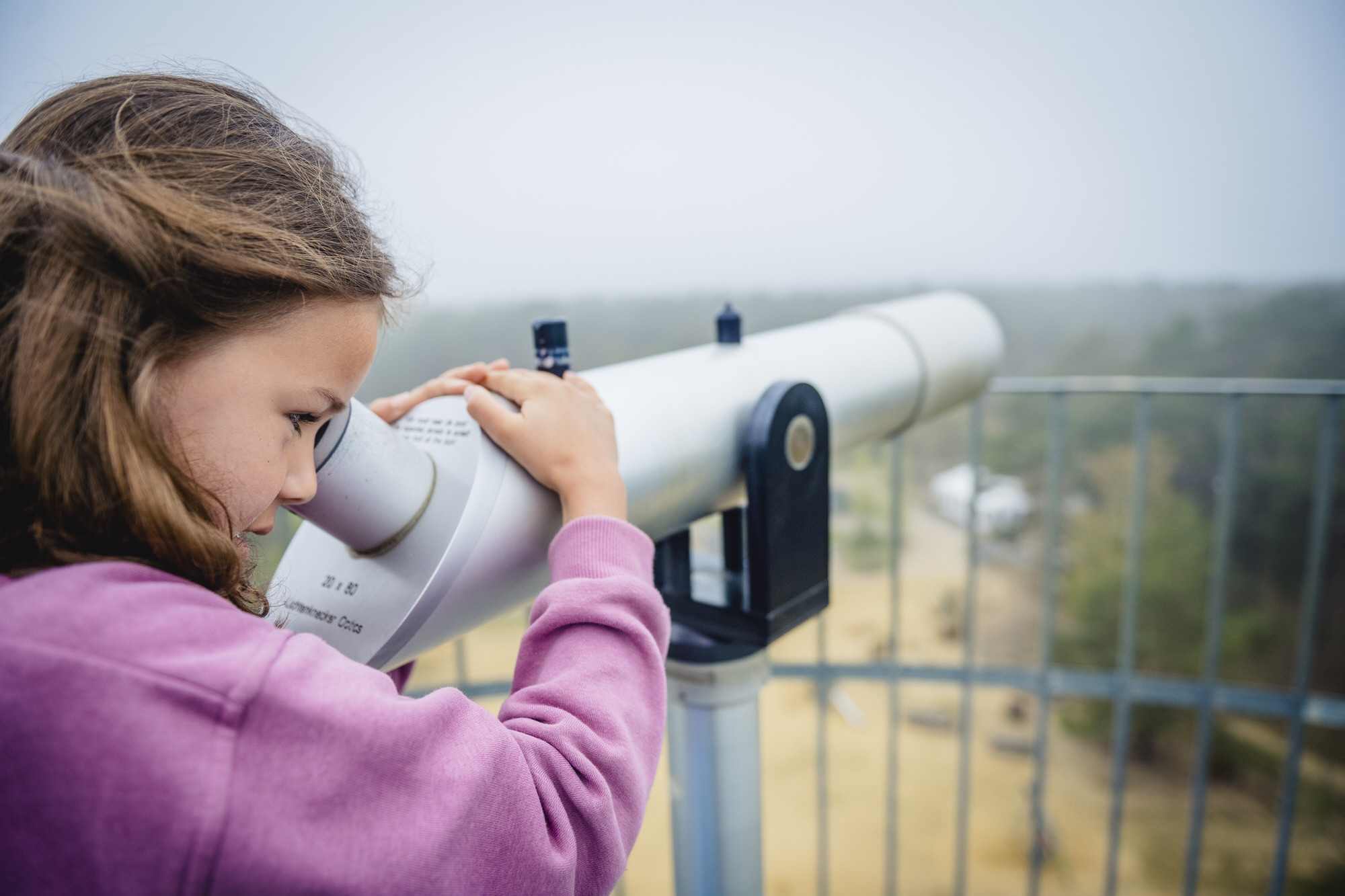 Meisje kijkt door telescoop op de uitkijktoren in Gerhagen