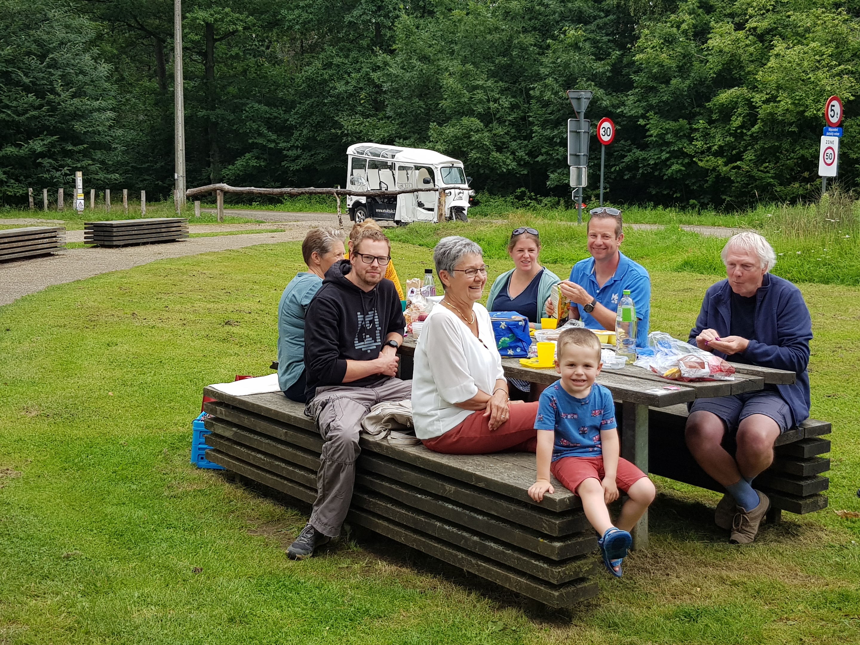 Groep mensen aan het picknicken in Hertberg na een tocht met de eTukTuk
